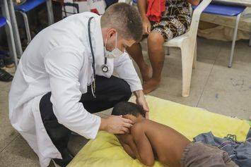 Médico examina criança em abrigo improvisado em escola municipal de Teresina